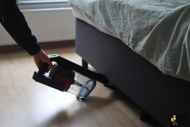 Man sieht den Shark Anti Hair Wrap Flexoloxy bei der Reinigung unter Möbeln.